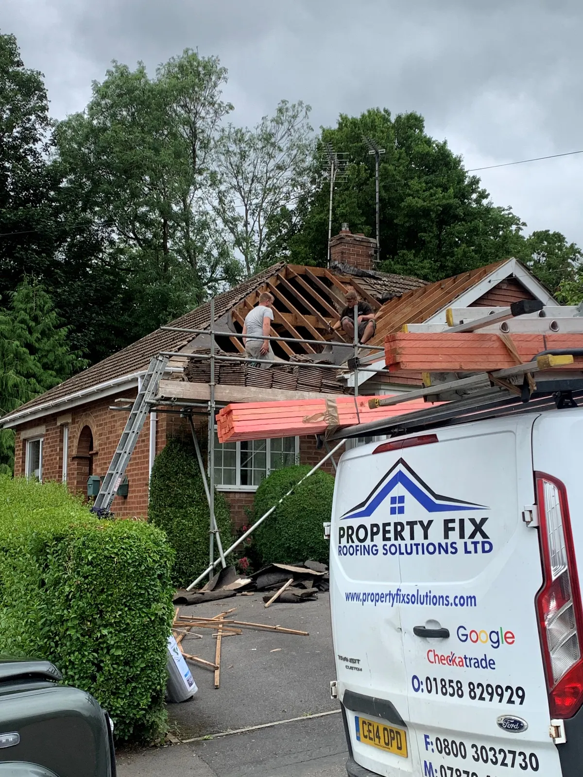 Roof replacement in progress with the company van on the drive