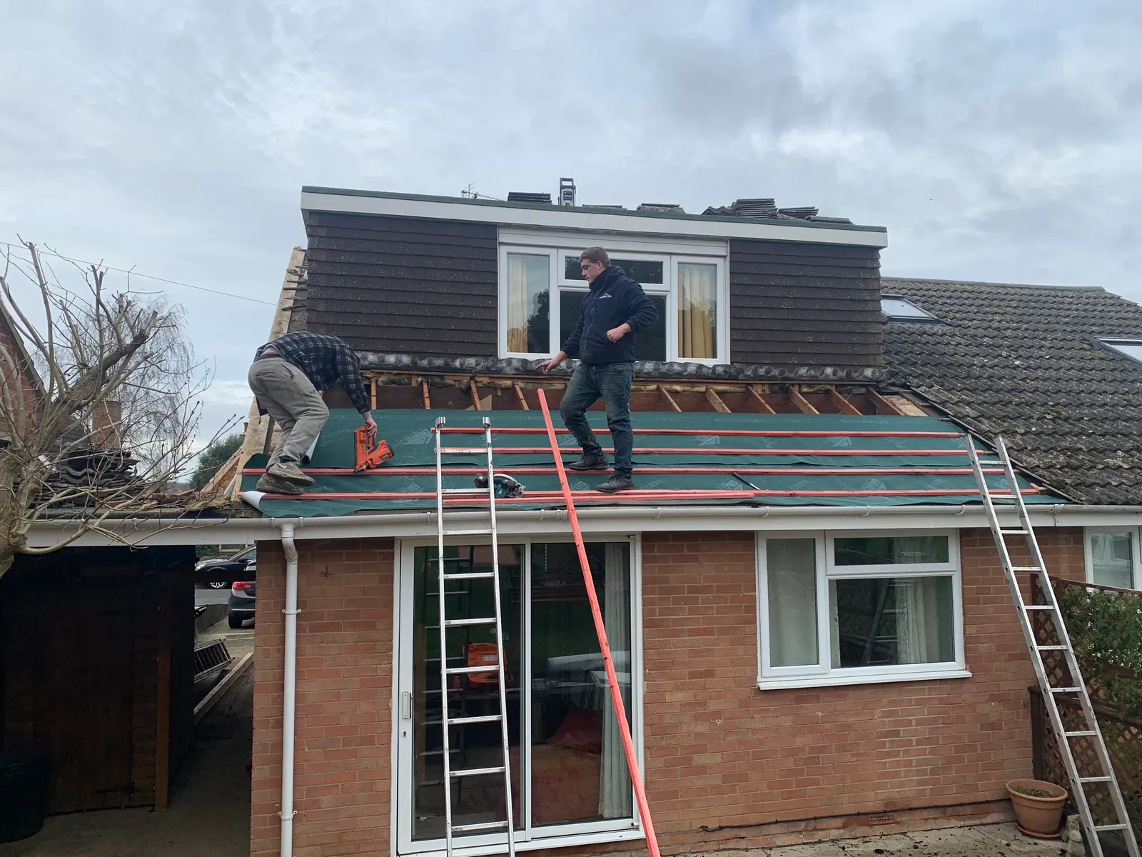 Roofers working on a dormer bungalow roof