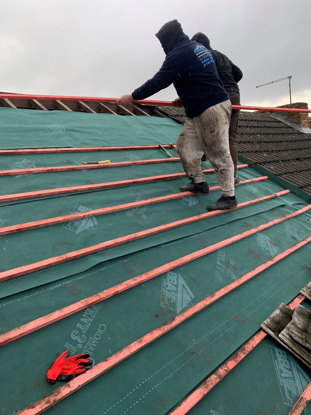 Roofer on a new roof with membrane and battens