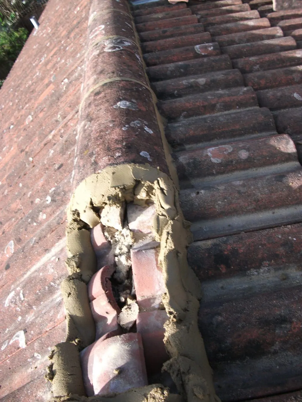 Ridge tiles being re bedded in mortar